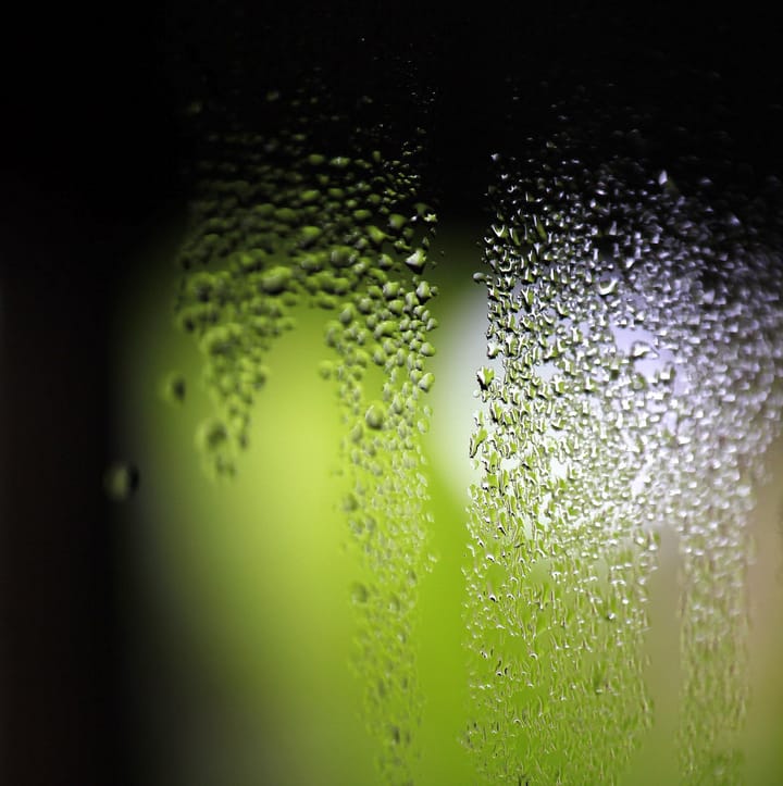 Condensation running down the inside of a cold window pane